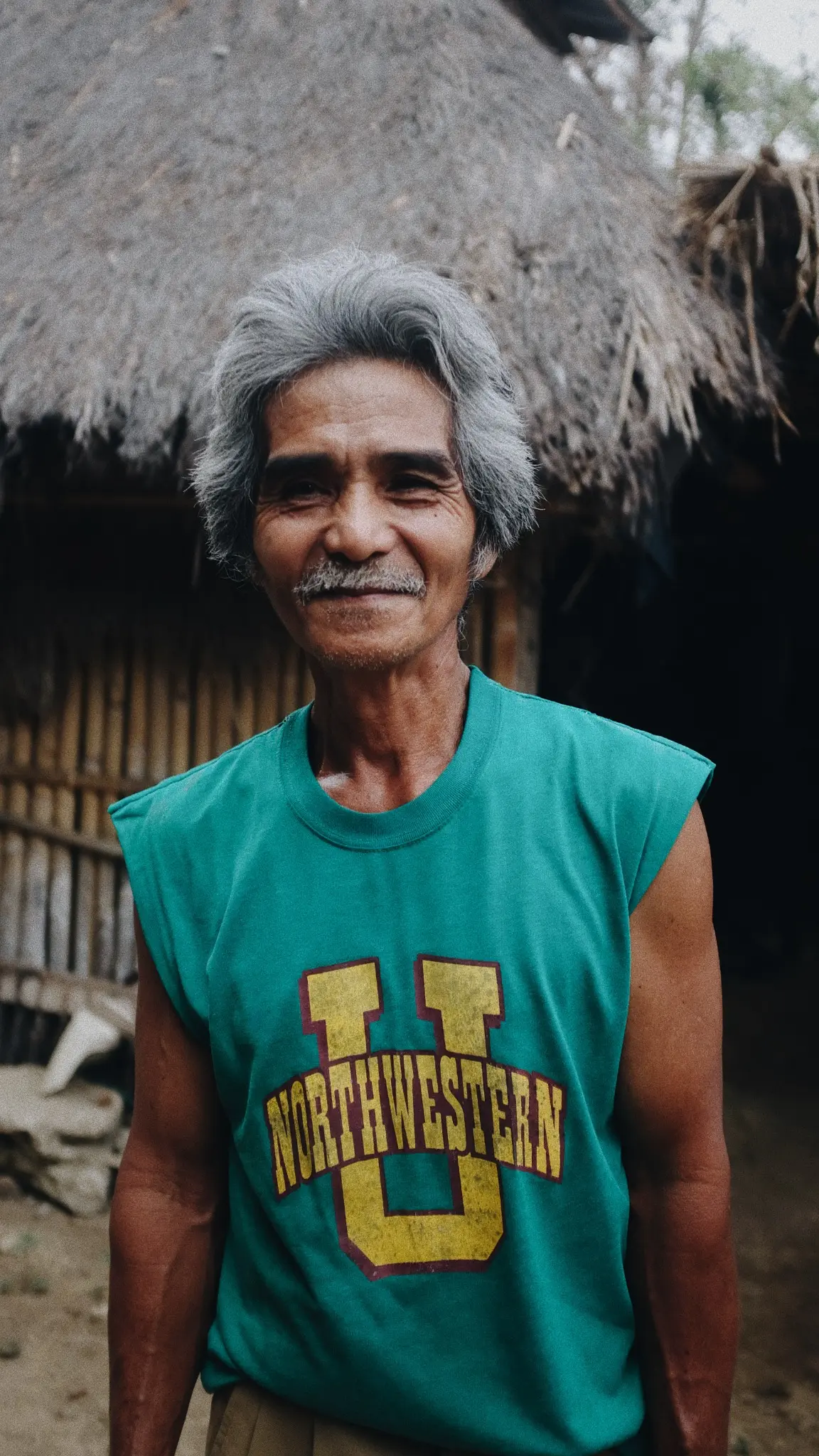 Portrait of a man beneath a thatched roof