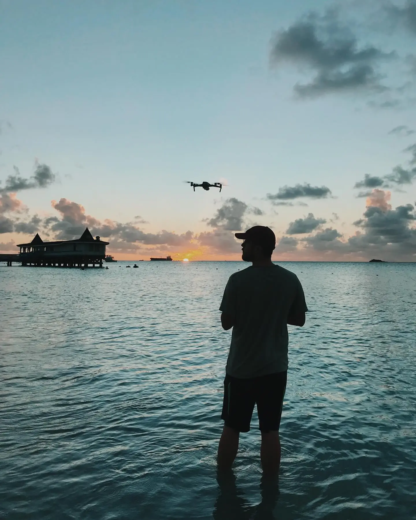 Silhouette beneath a sunset sky by the water