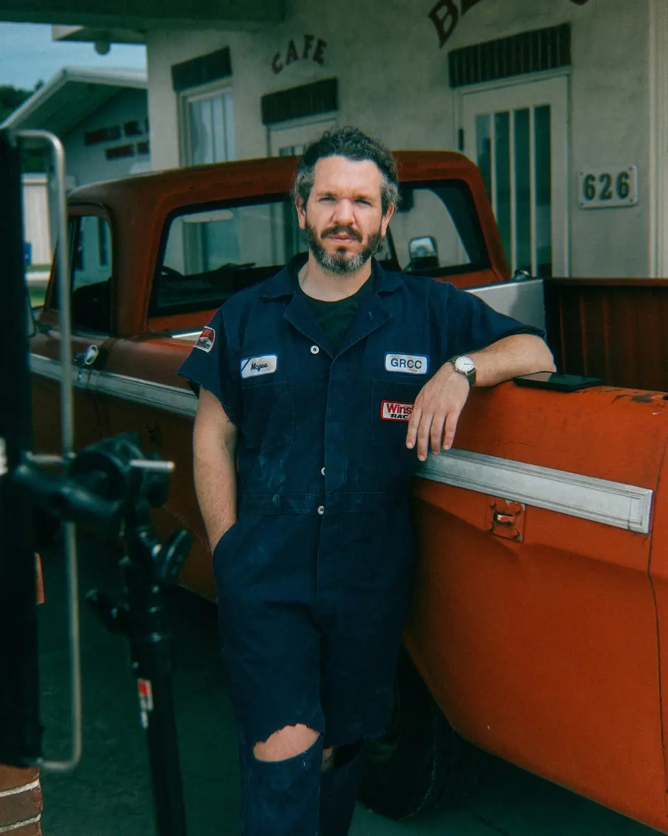 Traveler beside a vintage truck and roadside gas pump